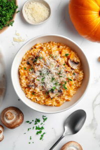 This image shows Parmesan cheese being mixed into the cooked risotto, creating a creamy, rich texture.