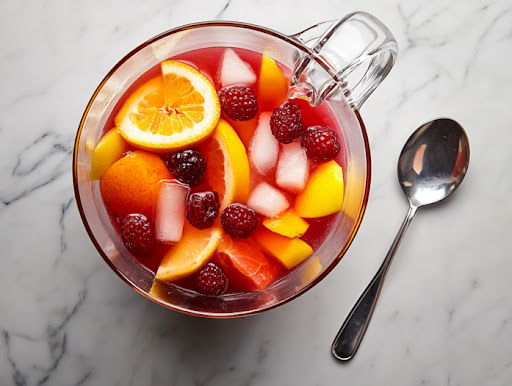 this image shows pina colada sangria in a pitcher garnished with pineapple slices