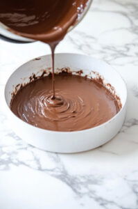 This image shows the smooth chocolate batter being poured into a greased or lined baking pan.