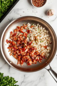 this image shows Onions sautéing in bacon drippings until softened, in the same pot.