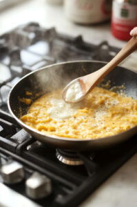 This image shows minced garlic being sautéed in the skillet with melted butter. The garlic is becoming soft and aromatic, filling the kitchen with its fragrance.