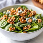 This image shows the completed salad, garnished with walnuts, ready to be served.