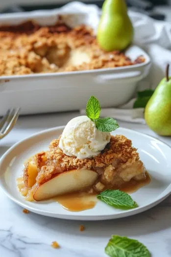 This image shows a slice of warm spiced pear cobbler on a plate, garnished with a scoop of salted caramel ice cream, ready to be enjoyed.]