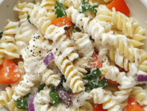 The image shows loaded pasta salad ready to serve