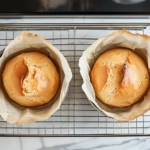 Each dough square is tightly rolled like a jelly roll on the white marble cooktop, with edges pinched to seal. The logs are rolled under palms to form uniform rounds.