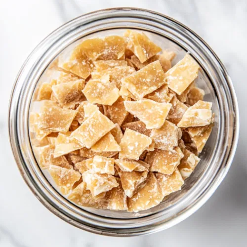 Storing the toffee saltine cracker pieces in an airtight container in the fridge, keeping them fresh and ready to enjoy