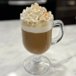 The finished frozen Irish coffee on the white marble countertop, garnished and ready to serve as a luxurious dessert beverage.