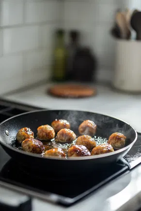 Parcels sizzling in a frying pan filled with bubbling oil on the white marble cooktop, creating a golden, crispy texture.