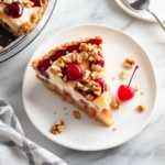 The Hawaiian Millionaire Pie rests on the white marble cooktop, sliced and ready to serve. A piece is displayed on a dessert plate, showcasing vibrant layers, garnished with a maraschino cherry and chopped walnuts.