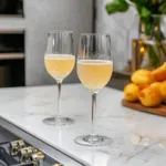 The completed Baby Bellini sparkling on the white marble countertop, ready to be served as a refreshing, non-alcoholic treat.