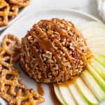 Roll the ball in the remaining pecans for a crunchy coating. Place on a serving platter, drizzle with extra caramel, and serve with apple slices, graham crackers, or pretzel chips for dipping.