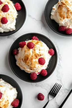 The Raspberry and Aperol Baked Alaska served beautifully browned on black plates over the white marble cooktop, showcasing the layers and textures of this elegant dessert.