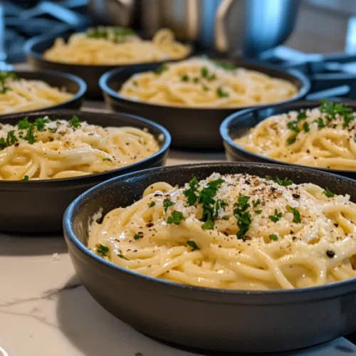 Creamy carbonara pasta is served in warm bowls on the white marble cooktop, garnished with extra Parmesan, black pepper, and parsley if desired. The pasta is ready to be enjoyed immediately.