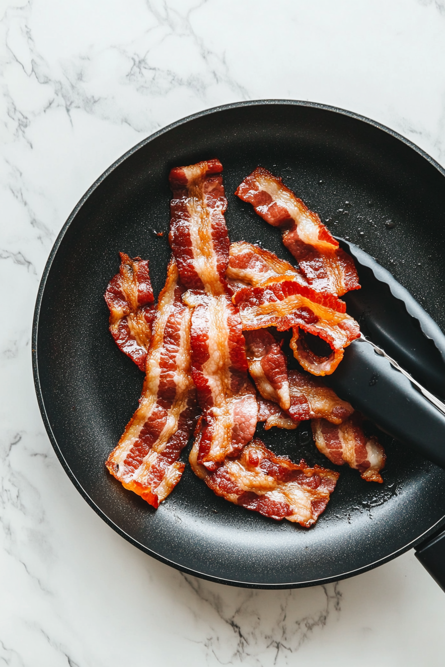 Crispy bacon pieces on a cutting board, freshly chopped after cooking.