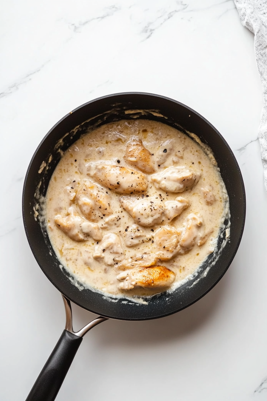 Cover and simmer for 10–12 minutes until chicken is fully cooked and the sauce thickens slightly. Taste and adjust seasoning if needed