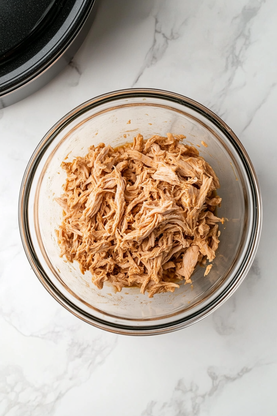 Remove chicken, shred the meat, and set aside. Strain the broth.
