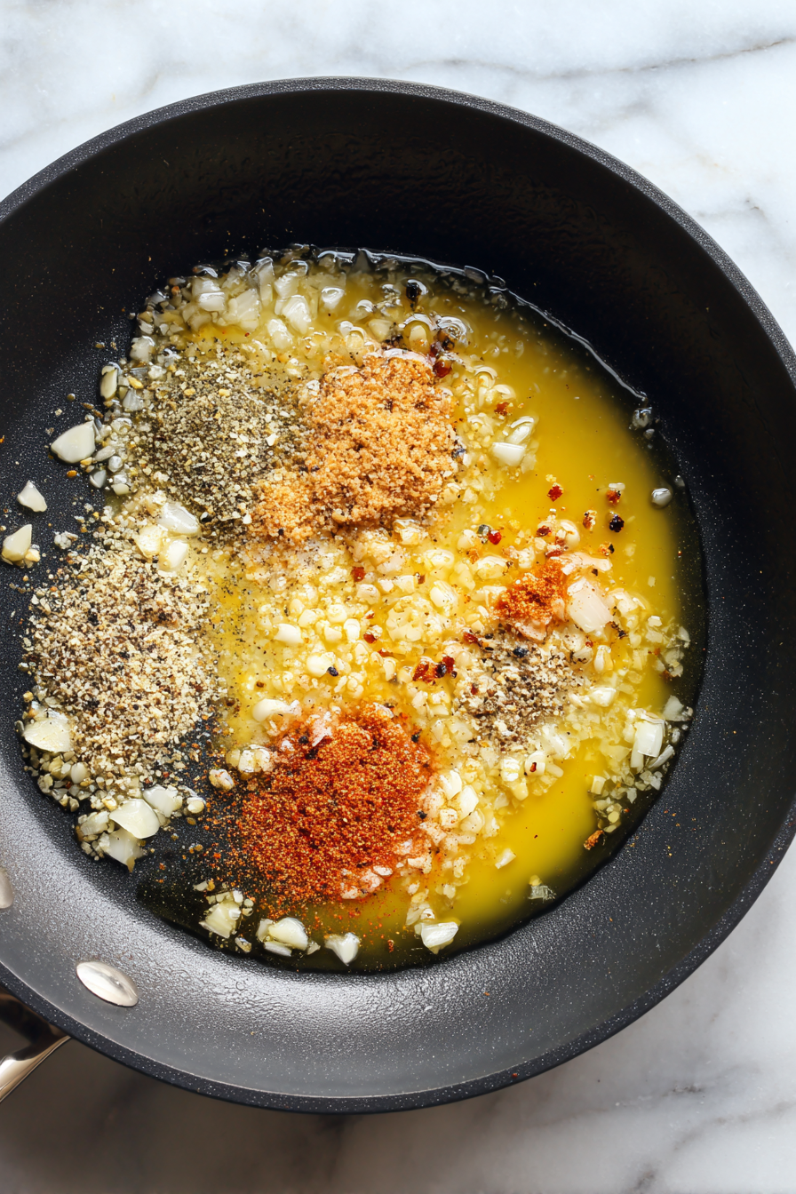 Add garlic, onion powder, paprika, chili flakes, salt, and pepper; sauté for 1 minute.