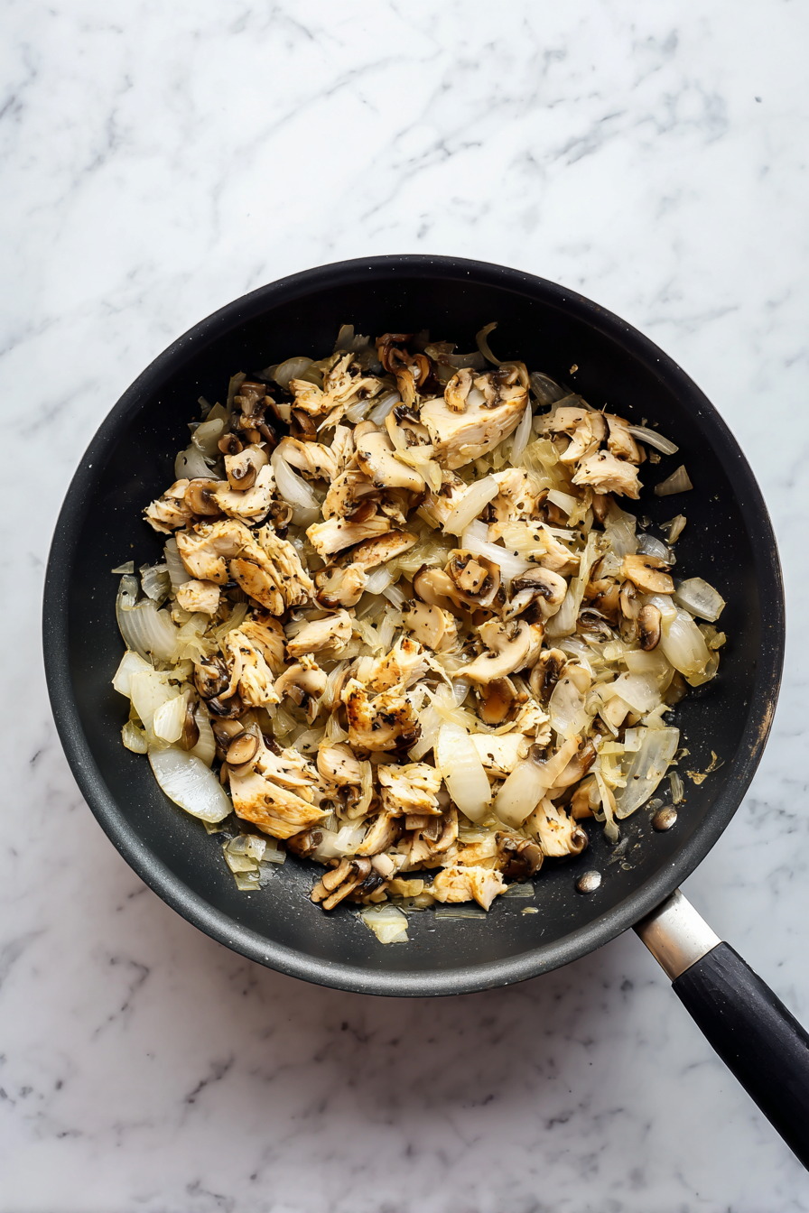 Add shredded chicken to the pan and mix well.
