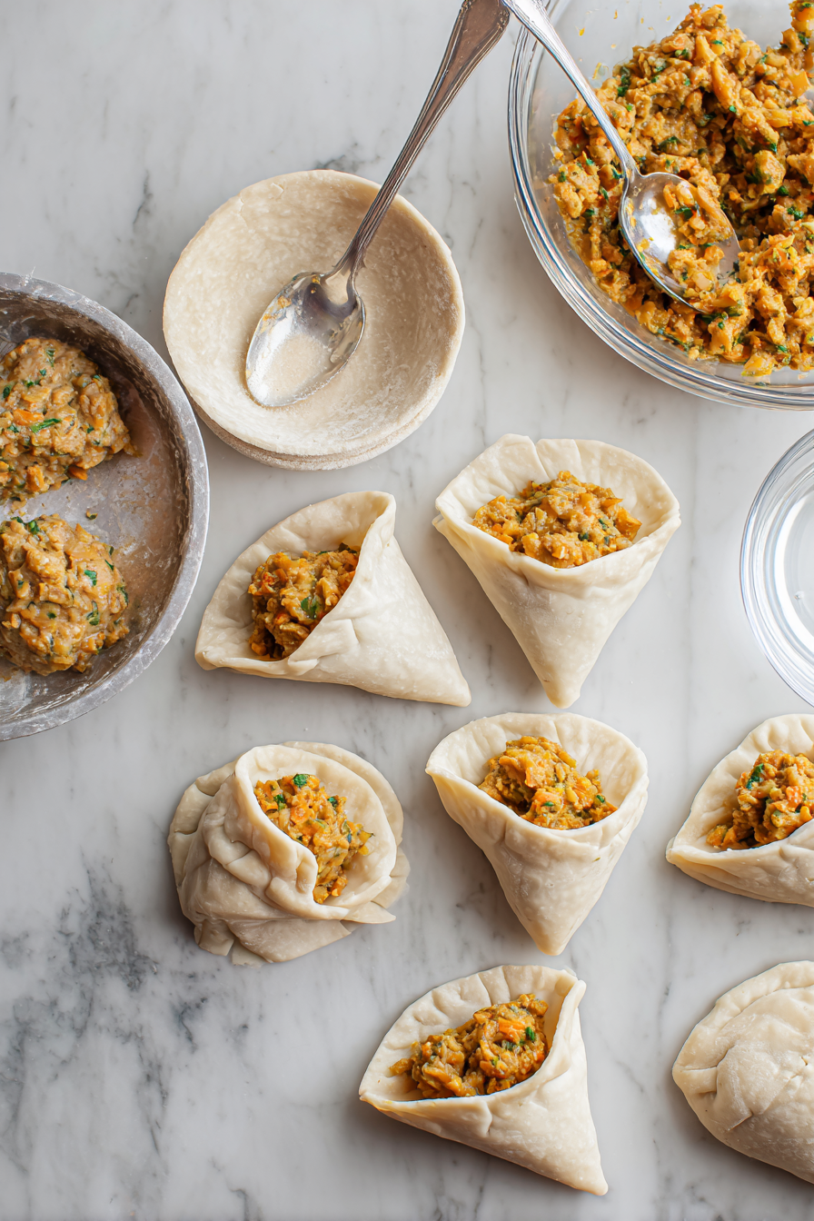 Divide the dough into small balls and roll each into an oval shape. Cut in half to form samosa wrappers.
