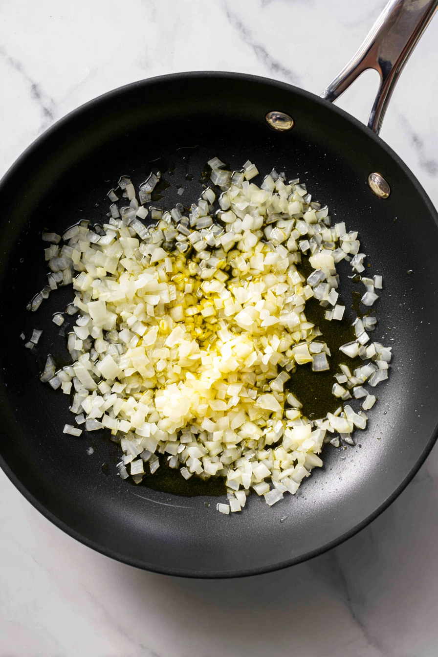 Heat oil in a skillet and sauté chopped onion until soft.