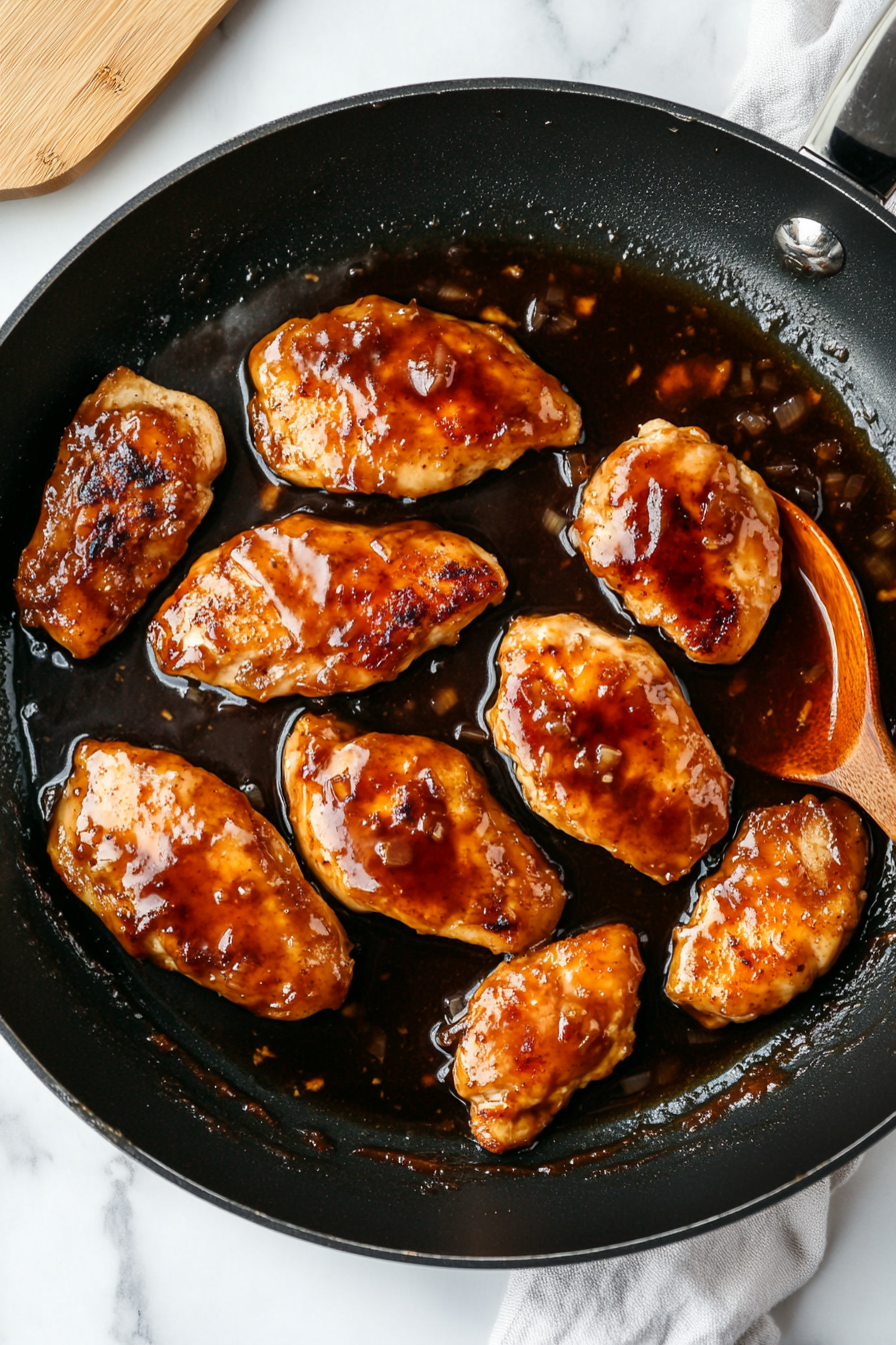 Pour glaze over the chicken and simmer until the sauce thickens and coats the chicken.