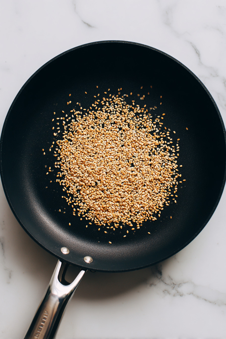 In a pan, toast sesame seeds until golden, then set aside.