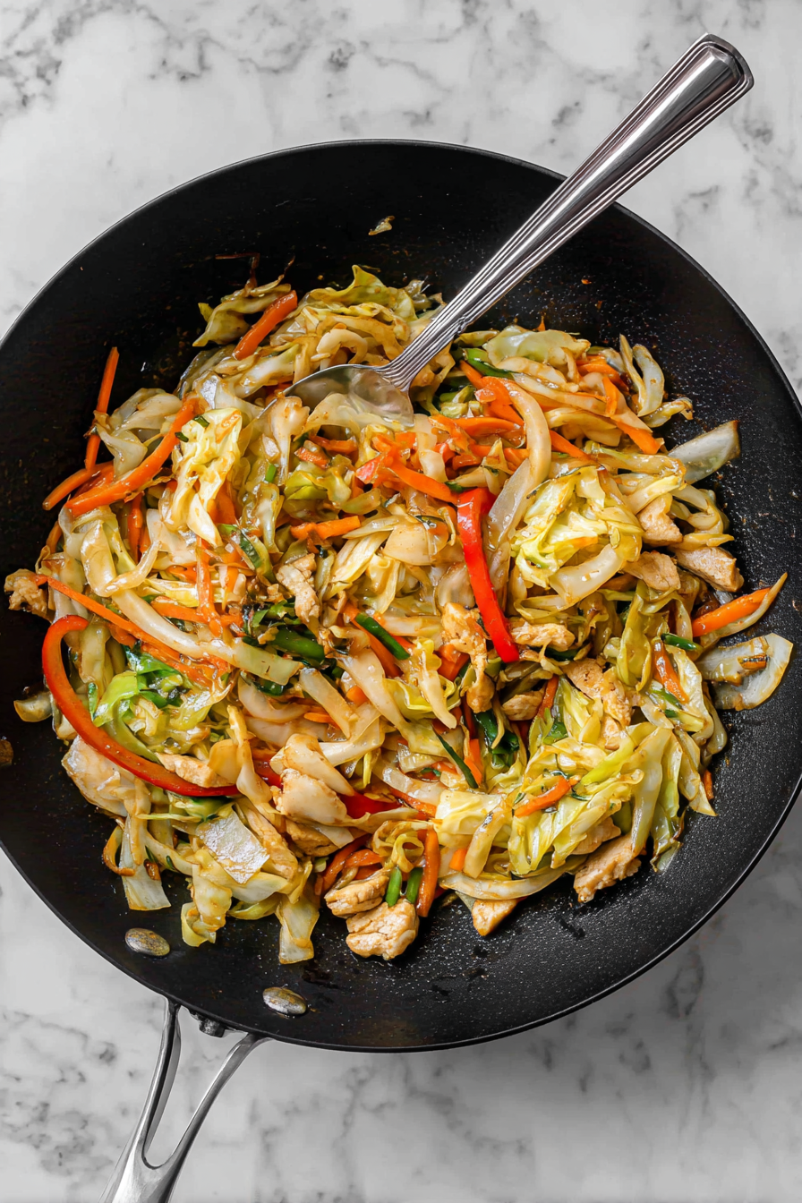 Toss in onion, cabbage, carrot, and capsicum—sauté for 3–4 minutes.