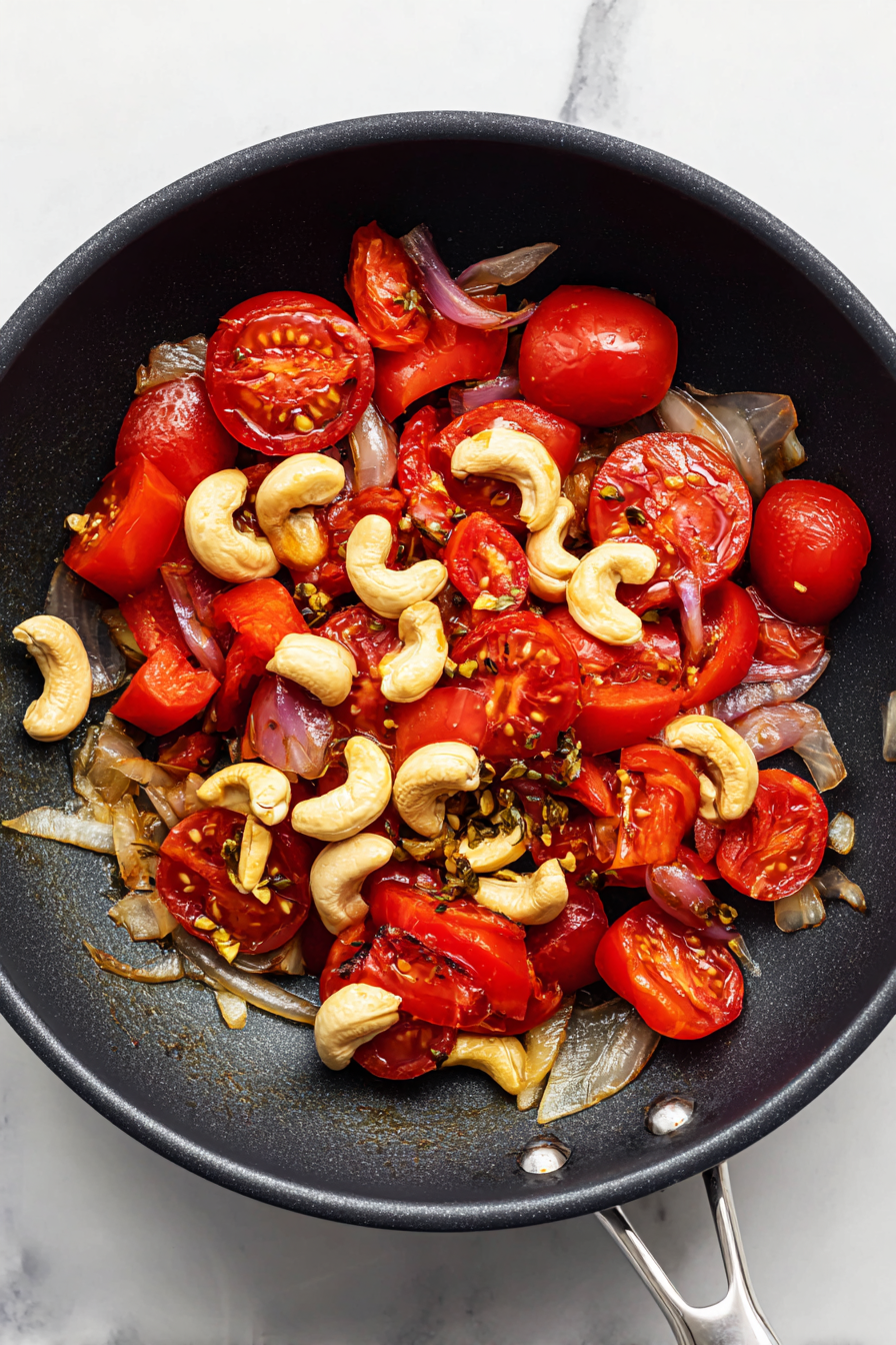 Add tomatoes and cashews; cook until soft, then blend to a smooth paste.