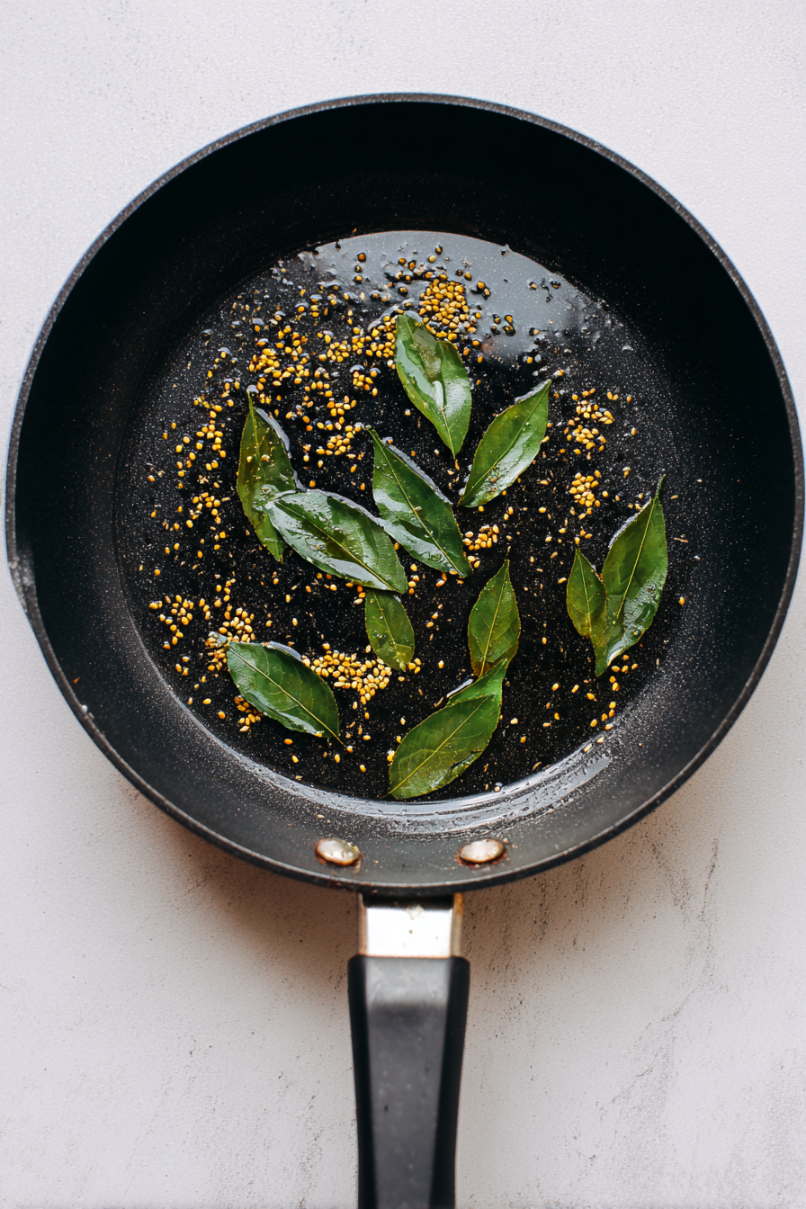 Add remaining oil, mustard seeds, cumin seeds, and curry leaves; let them splutter.