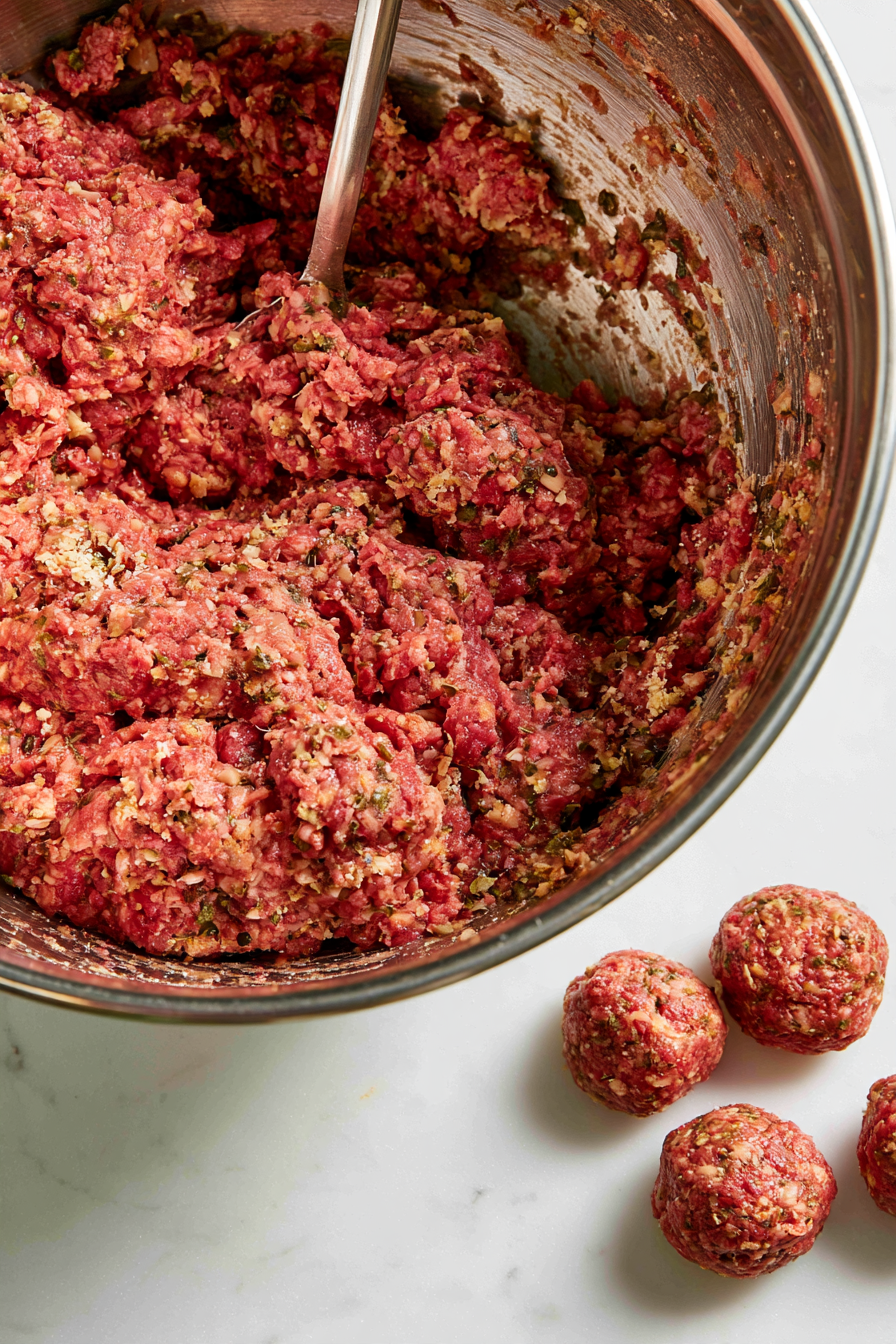 Combine ground beef, breadcrumbs, milk, egg, minced garlic, thyme, sage, and a pinch of salt and pepper in a large bowl