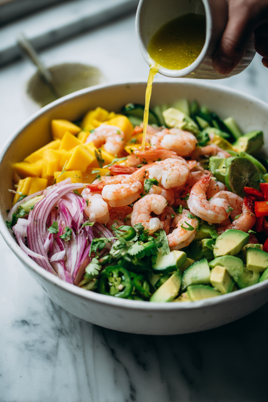 Add the cooked shrimp to the salad bowl and pour the dressing over the top